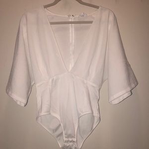 White body suit with deep v-neck. Never Worn!